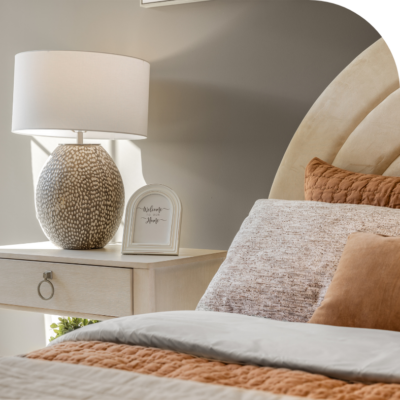 Closeup of a bed with pillows to show 2025's design trend of muted colors.